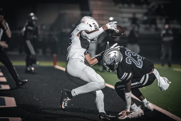 Night football game, a receiver making a catch under stadium lights